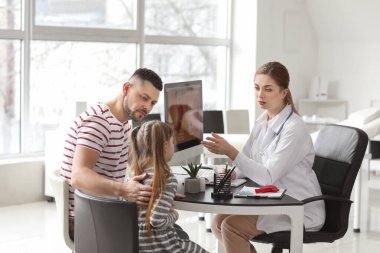 Küçük kızıyla birlikte bir adam klinikte gastroenteroloğu ziyaret ediyor.