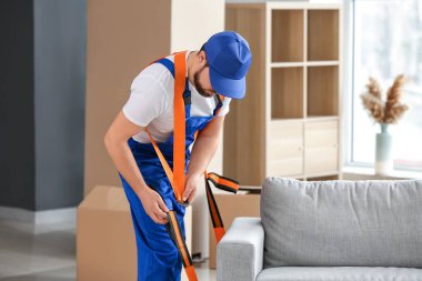 Yükleyici mobilya taşımak için kargo kemeri kullanıyor