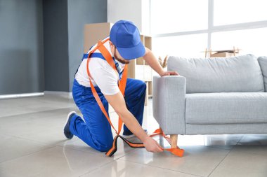 Yükleyici mobilya taşımak için kargo kemeri kullanıyor