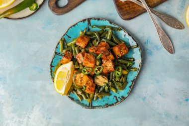 Renkli arkaplanda lezzetli tofu peyniri ve sebze tabağı.