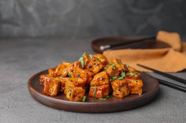 Koyu arkaplanda lezzetli tofu peyniri olan tabak.