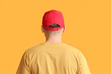 Renkli arka planda şık şapkalı yakışıklı bir adam.