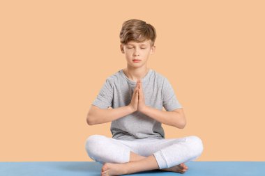 Renkli arka planda yoga yapan sevimli küçük çocuk.