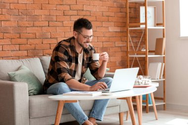 Evde çalışan dizüstü bilgisayarı olan adam.