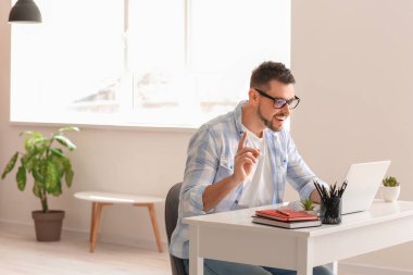 Evde çalışan dizüstü bilgisayarı olan adam.