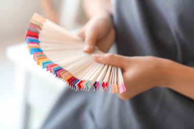 Güzellik salonunda tırnak cilası uçlarıyla kadın manikür ustası, yakın plan.