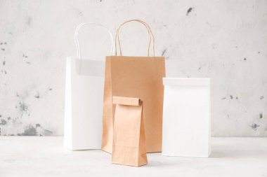 Masadaki kağıt torbalar ışık arkaplanına karşı