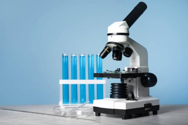 Modern mikroskop ve test tüpleri masada.
