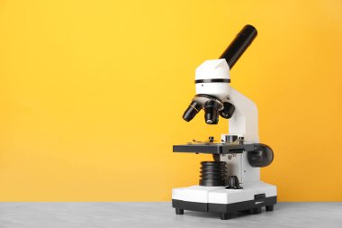 Masadaki modern mikroskop renk arkaplanına karşı