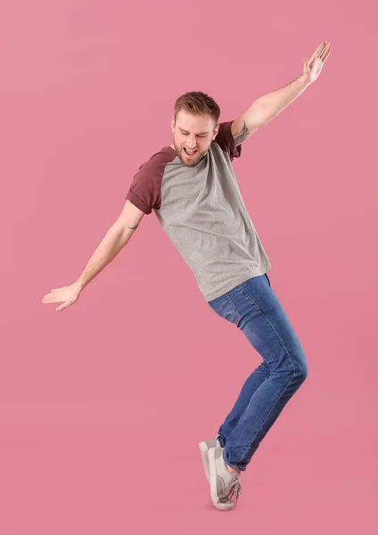 Handsome dancing man on color background