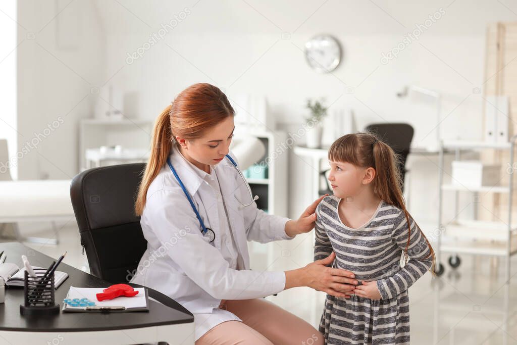 Gastroenterologist examining little girl in clinic