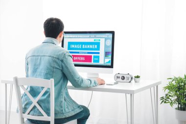 Evde bilgisayarla çalışan Asyalı genç bir adam.