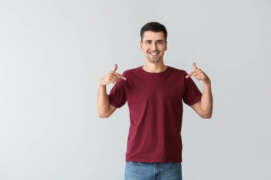 Gri arka planda şık tişörtlü adam.