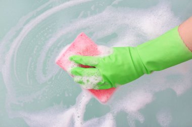 Ev hanımı evde pencere temizliyor.