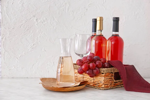 Decanter with bottles of wine on white background