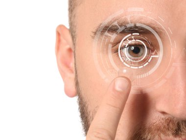 Genç adam beyaz arka plana kontak lens takıyor, yakın plan.