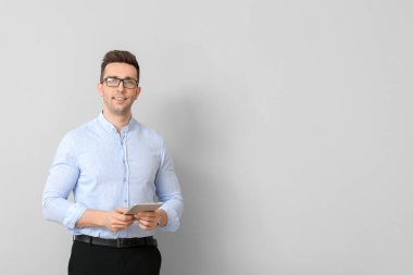 Hafif arka planda tablet bilgisayar ile Yakışıklı işadamı