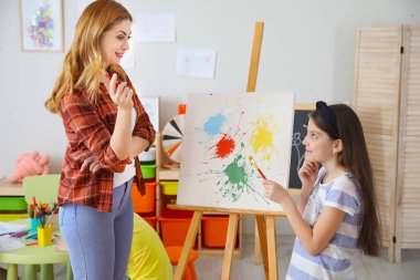 Okulda resim öğretmeni dersleri veriyor.