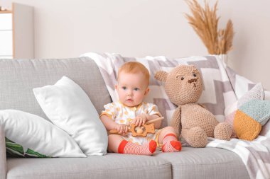 Evinde oyuncakları olan şirin bir bebek.