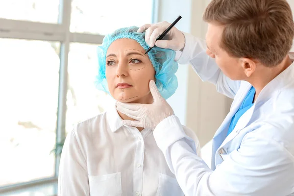 성형외과 의사가 클리닉에서 여성의 얼굴에 칼자국을 이식하는 — 스톡 사진