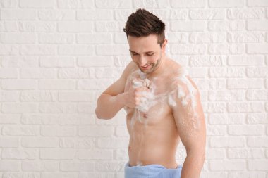 Beyaz arka planda duş alan yakışıklı adam.