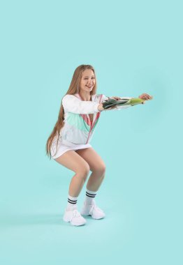 Pırasalı genç bir kadın, renkli arka planda çömelme yapıyor. Diyet kavramı