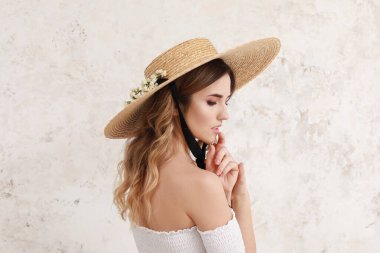 Açık arkaplanda bir demet leylak çiçeğiyle güzel genç bir kadın.