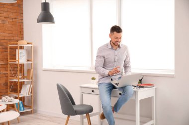 Evde çalışan dizüstü bilgisayarı olan adam.