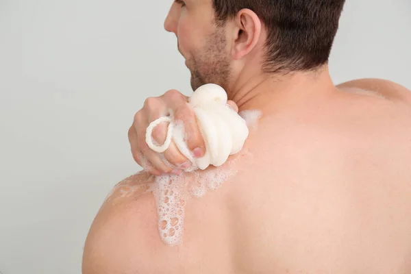 Hombre Guapo Tomando Ducha Contra Fondo Claro —  Fotos de Stock