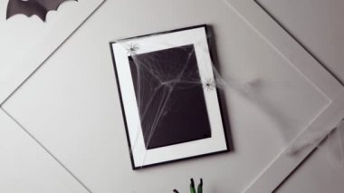 Cadının elleri arka plandaki boş fotoğraf çerçevesine dokunuyor. Cadılar Bayramı