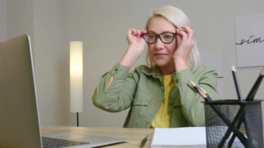 Evde online öğrenim için dizüstü bilgisayar kullanan olgun bir kadın