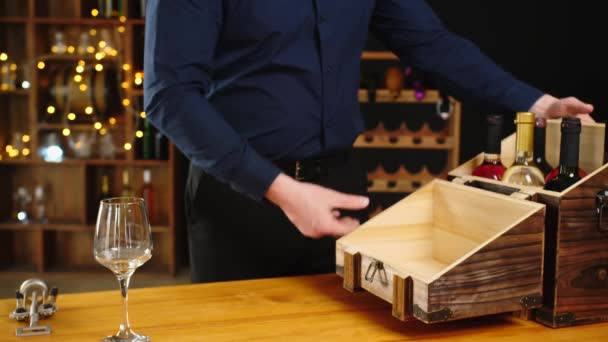 男人从盒子里取出酒瓶 在地窖里打开一瓶昂贵的酒 — 图库视频影像