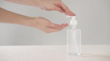 Beyaz arka planda dezenfektan kullanan kadın