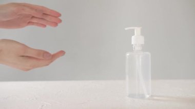 Beyaz arka planda dezenfektan kullanan kadın