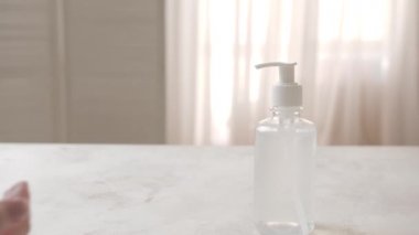 Evde dezenfektan kullanan bir kadın.