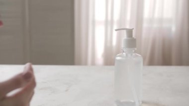 Evde dezenfektan kullanan bir kadın.