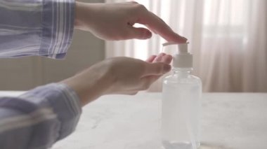 Evde dezenfektan kullanan bir kadın.