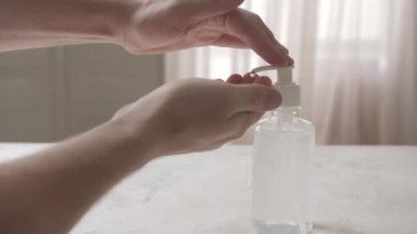 Evde dezenfektan kullanan adam.