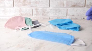 Sağlık çalışanı masadan koruyucu maskeyi alıyor.