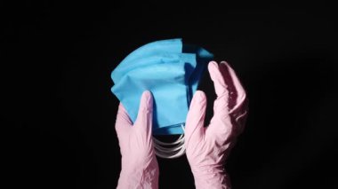 Siyah arka planda koruyucu maskeleri olan bir tıp çalışanı.