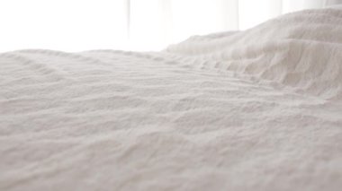 Yatağı yumuşak battaniyeyle örten kadın.