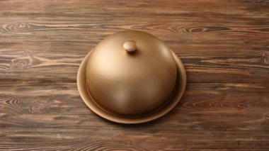 Erkek garson, ahşap arka planda tıbbi koruyucu maskeli tepsiyi açıyor.