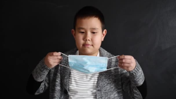 Asiatisk Pojke Bär Skyddsmask Och Visar Tummen Upp Gest Mörk — Stockvideo