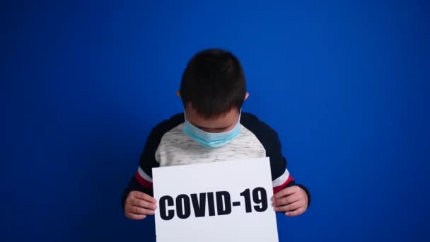 Asiatischer Junge Schutzmaske Mit Papierbogen Mit Text Covid Auf Farbigem — Stockvideo