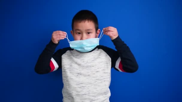 Asiatisk Pojke Bär Skyddsmask Och Visar Tummen Upp Gest Färg — Stockvideo