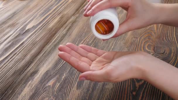 Vrouw Met Visolie Capsules Aan Houten Tafel — Stockvideo