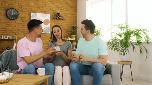 和孕妇在家里喝茶的同性恋夫妇 代孕母亲概念 — 图库视频影像