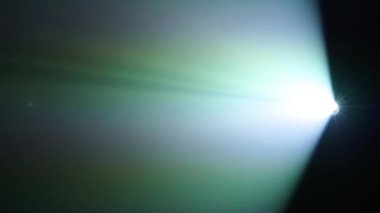 Koyu arkaplana karşı projektörün parlak renk demeti