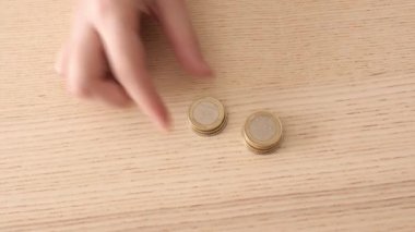Ahşap masada bozuk para sayan bir kadın. Borç kavramı