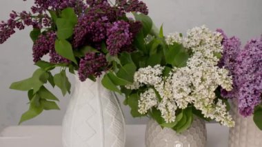 Masada güzel leylak buketleri olan vazolar.